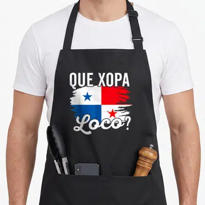 Camiseta panamanian apron - Distressed Panamanian flag with Que Xopa Loco text in white red and blue — shown on a black cotton canvas apron against a white background