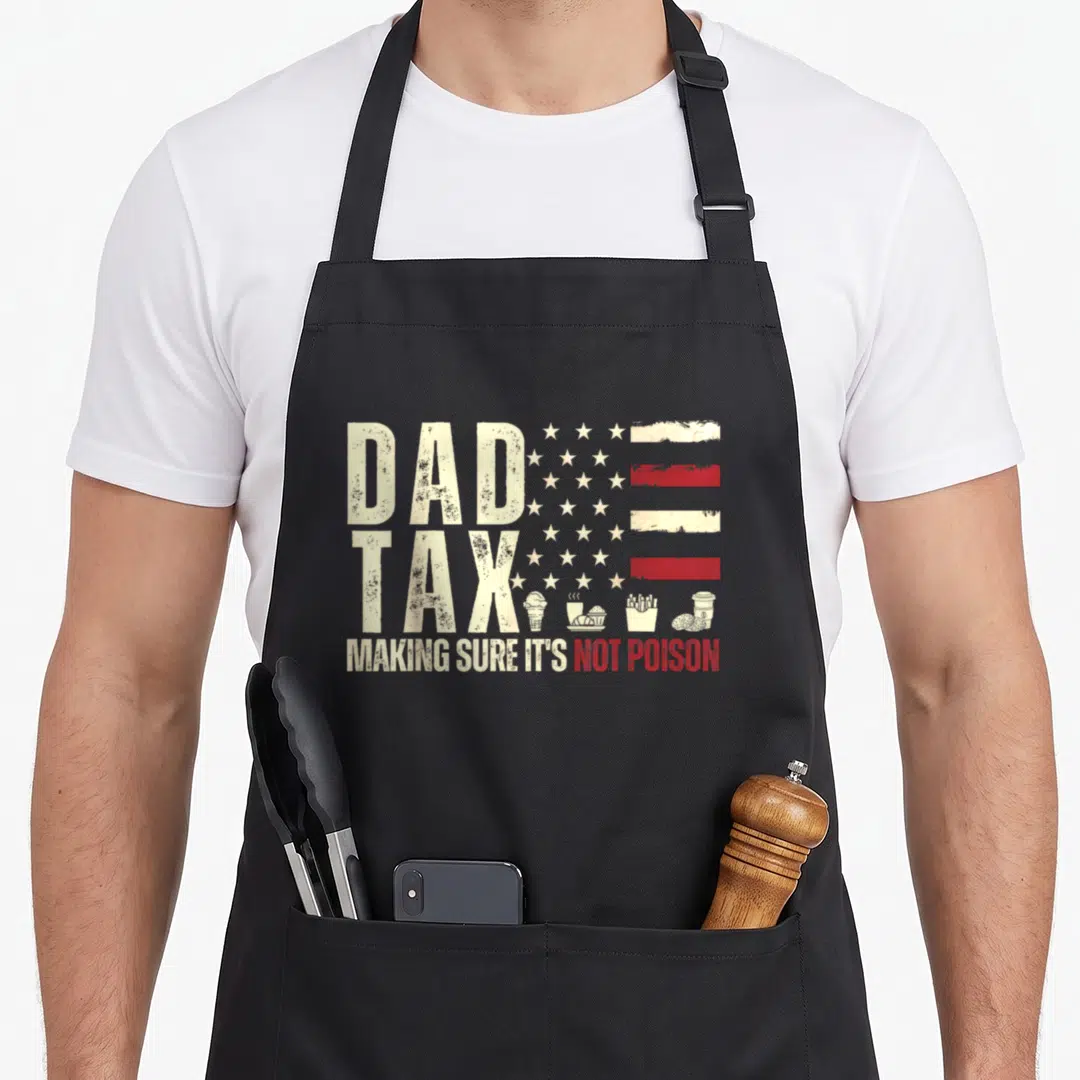 Flag making an apron - Distressed white and red USA flag with DAD TAX text and small icons of ice cream, coffee, fries — shown on a black cotton canvas apron against a white background