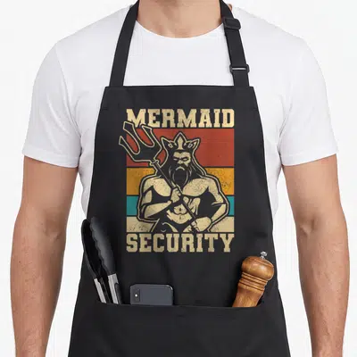Security bday birthday apron - Retro Poseidon holding trident on red orange teal stripes with Mermaid Security text — shown on a black cotton canvas apron against a white background