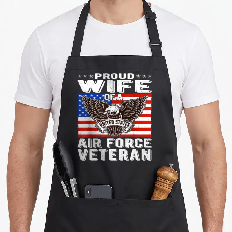 Force patriotic apron - Distressed eagle over flag with Proud Wife of US Air Force Veteran text — shown on a black cotton canvas apron against a white background