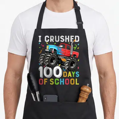 School truck aprons - I crushed 100 days of school monster truck with confetti — shown on a black cotton canvas apron against a white background