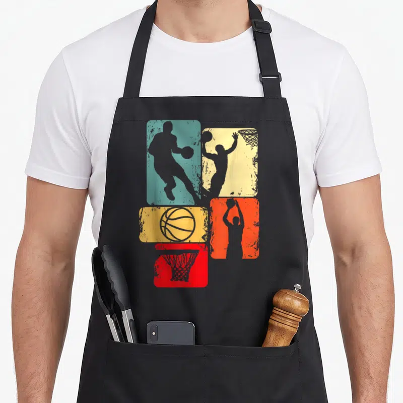 Retro player basketball apron - Four teal yellow orange and red rectangles with grey basketball player ball and hoop — shown on a black cotton canvas apron against a white background