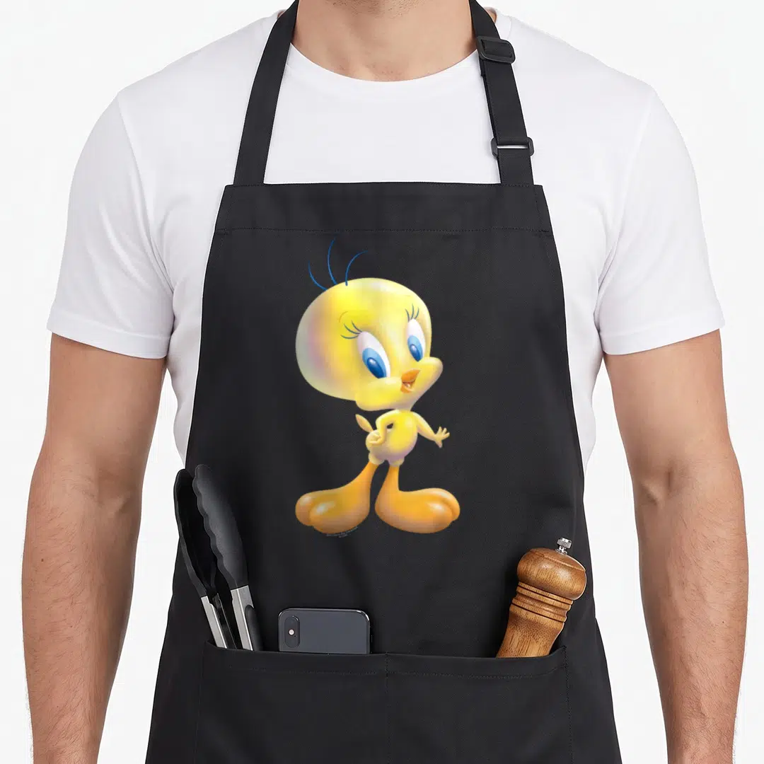 Tweety airbrushed bird apron - Yellow cartoon bird with blue eyes and orange feet standing on grey background — shown on a black cotton canvas apron against a white background