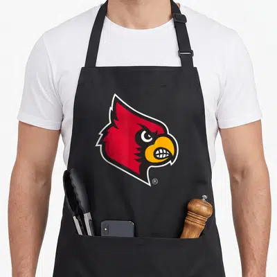 Louisville cardinal apron - Red cartoon cardinal head facing right with yellow beak and white border outline — shown on a black cotton canvas apron against a white background