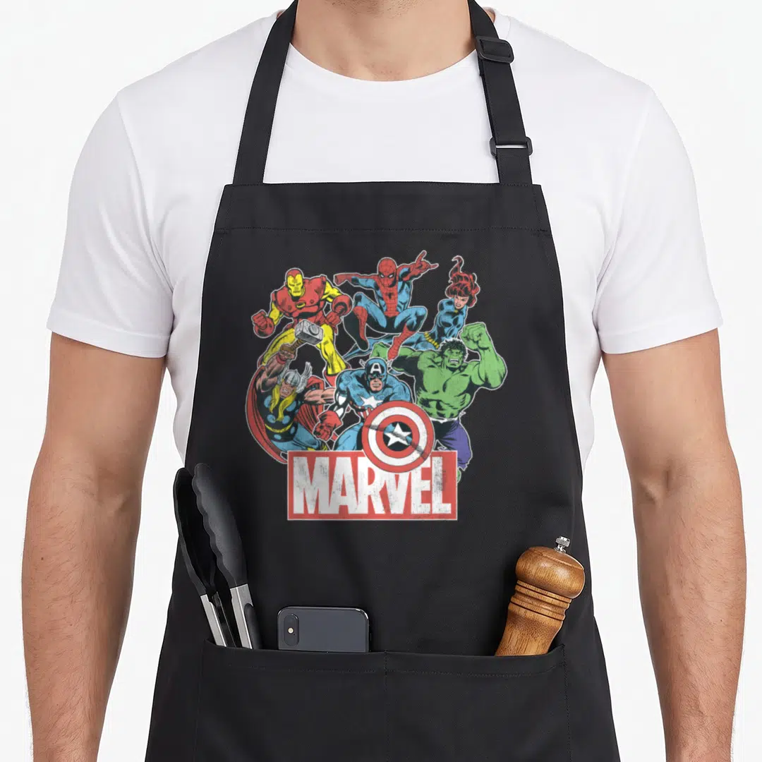 Comic general apron - Six Avengers superheroes in dynamic poses above red MARVEL logo box — shown on a black cotton canvas apron against a white background