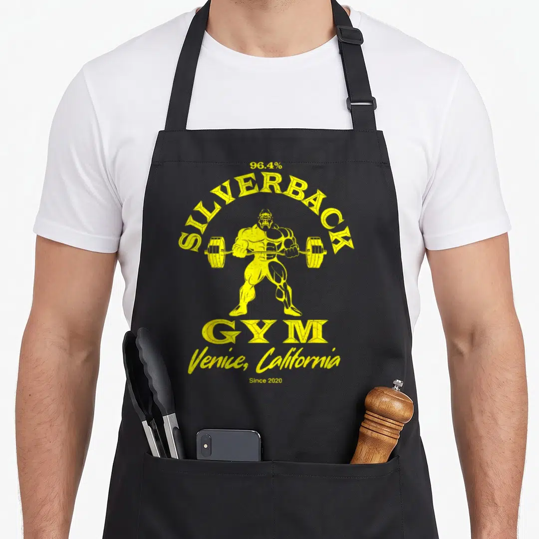 Venice silverback aprons - Yellow distressed gorilla lifting barbell with 96.4% Silverback Gym text — shown on a black cotton canvas apron against a white background