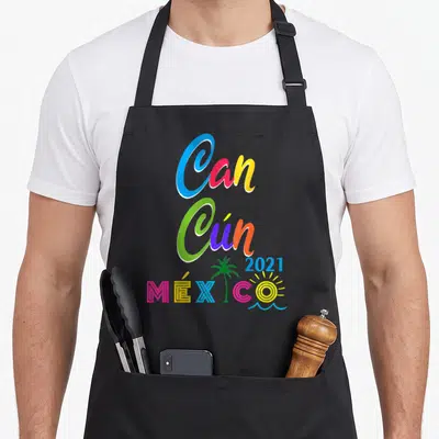 Cancun family aprons - Stacked Can Cún 2021 MÉXICO text with palm tree sun and waves in blue green orange pink yellow — shown on a black cotton canvas apron against a white background