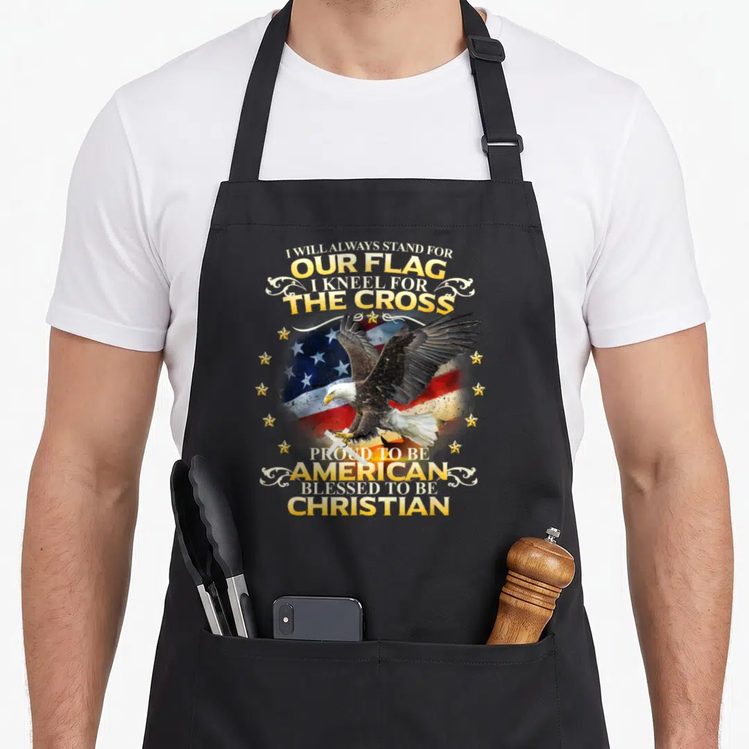 Christian patriotic aprons - Eagle clutching white cross over US flag with stacked patriotic Christian text in gold — shown on a black cotton canvas apron against a white background