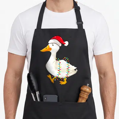 Duck christmas lights apron - Cartoon white duck wearing red santa hat wrapped in multicolored Christmas lights — shown on a black cotton canvas apron against a white background