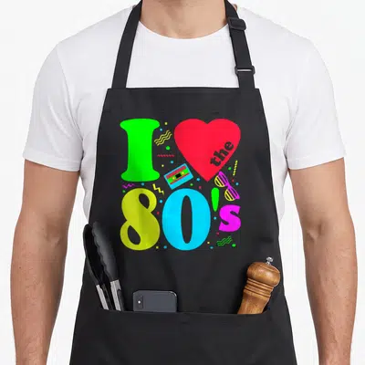 Funny 90s 80s apron - Neon I, red heart with the, 80s text, cassette, sunglasses, geometric shapes in cartoon style — shown on a black cotton canvas apron against a white background