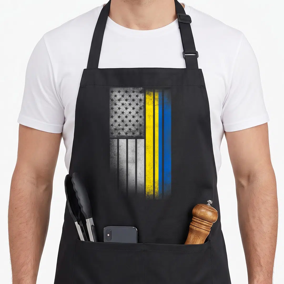 Funny ukrainian american flag apron - Vertical distressed flag design with grey stars and yellow blue stripes — shown on a black cotton canvas apron against a white background