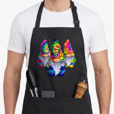Three hippie apron - Three tie-dye gnomes with white peace sign on center hat — shown on a black cotton canvas apron against a white background