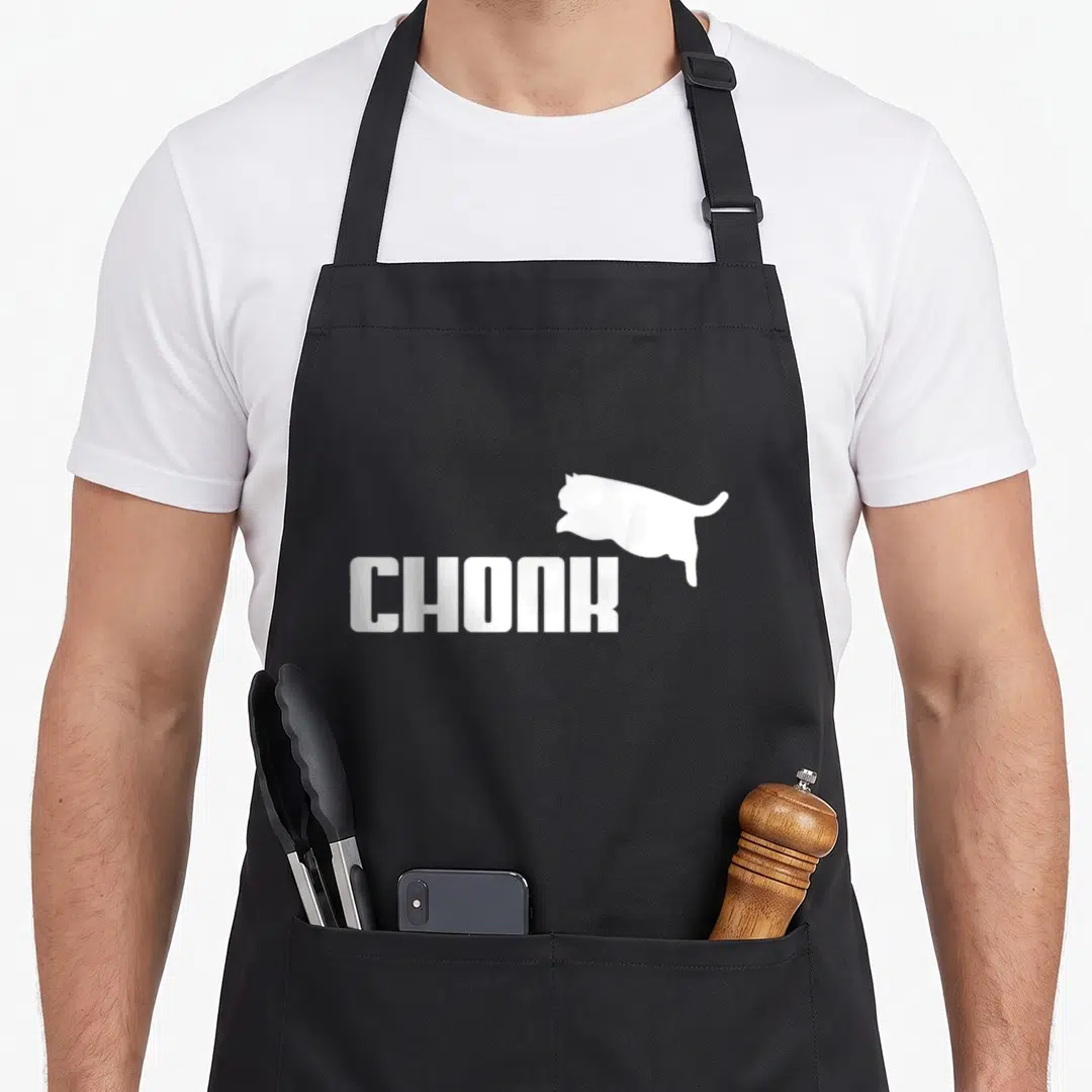 Chonk meme cat apron - White CHONK text with a cat silhouette positioned above and to the right — shown on a black cotton canvas apron against a white background
