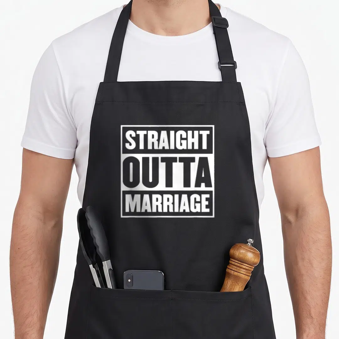 Straight marriage apron - White stacked text reading STRAIGHT OUTTA MARRIAGE inside a rectangular border on black fabric — shown on a black cotton canvas apron against a white background
