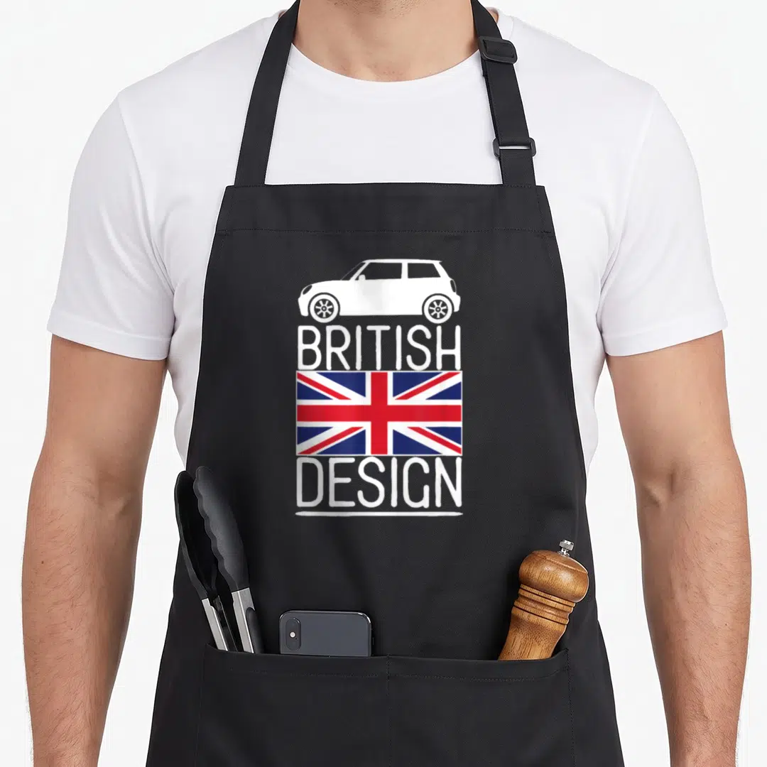 Cute car apron - White car silhouette above BRITISH DESIGN text and red white blue Union Jack flag — shown on a black cotton canvas apron against a white background