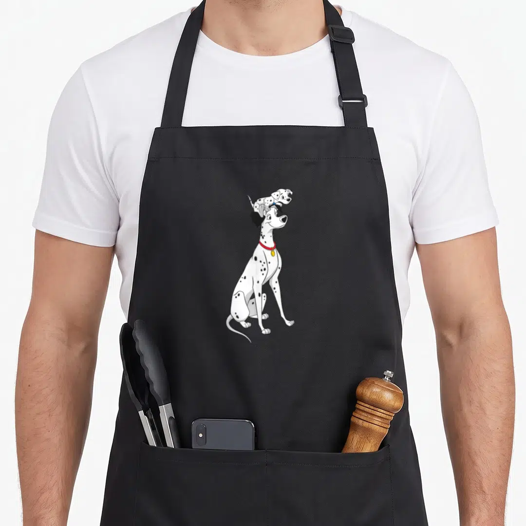 Funny pongo dalmatian apron - Sitting Dalmatian with red collar and puppy perched on head in cartoon style — shown on a black cotton canvas apron against a white background