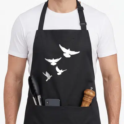 Dove flying apron - Four white doves in flight poses on a plain background — shown on a black cotton canvas apron against a white background