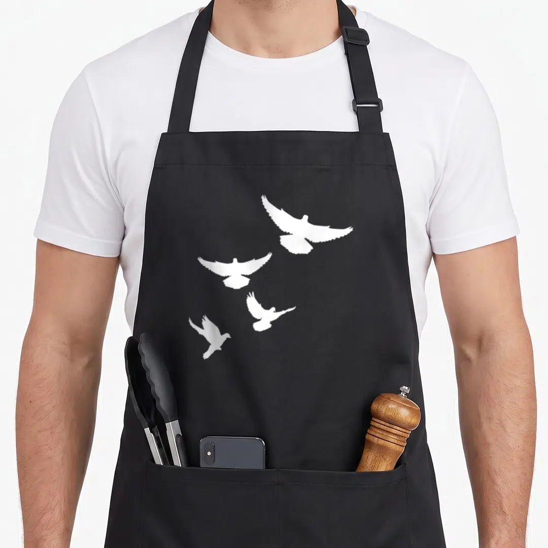 Dove flying apron - Four white doves in flight poses on a plain background — shown on a black cotton canvas apron against a white background