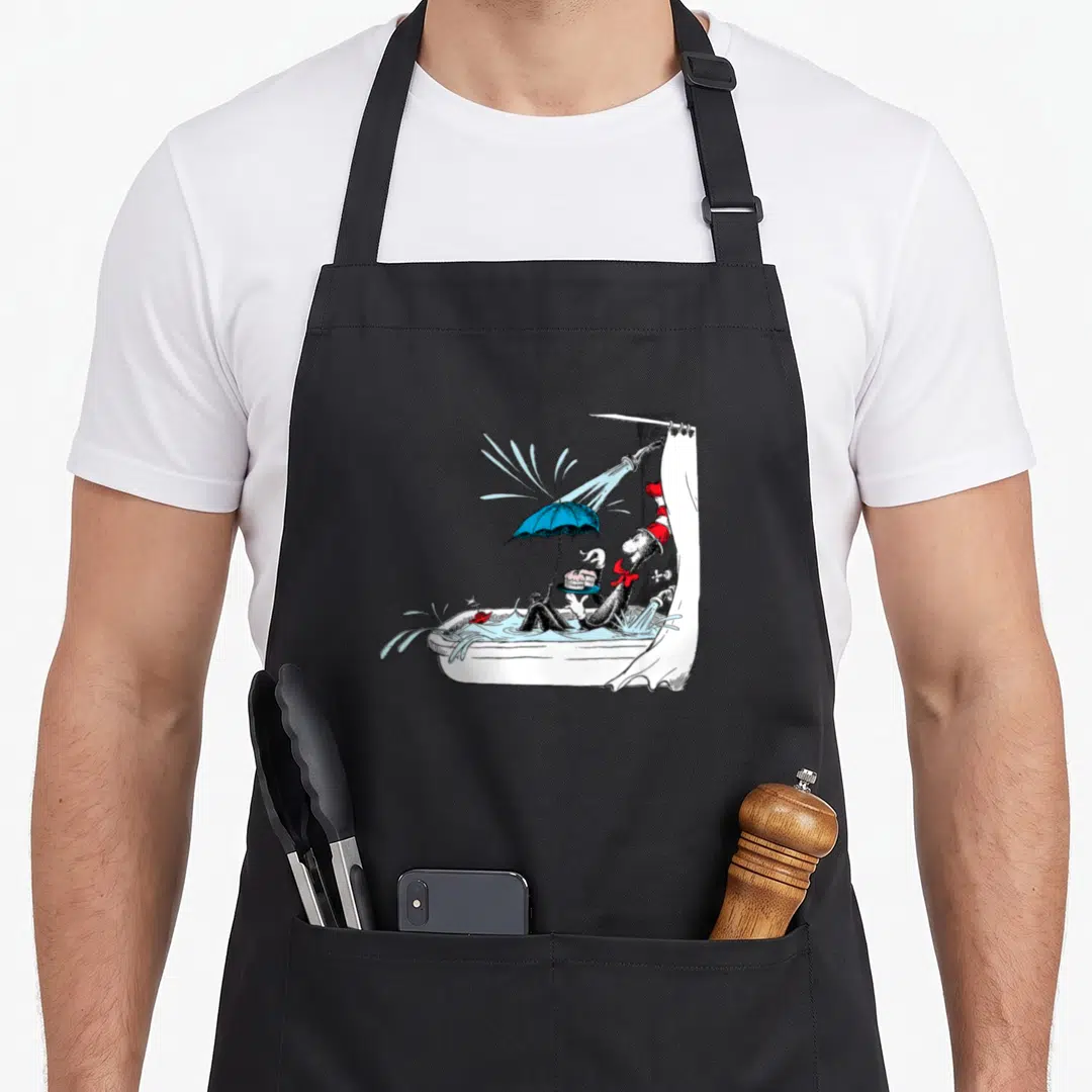 Tub cake apron - Black cat in red white hat holding cake under blue umbrella in white bathtub — shown on a black cotton canvas apron against a white background