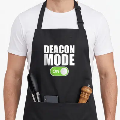Minister christian apron - White DEACON MODE text above green toggle switch reading — shown on a black cotton canvas apron against a white background