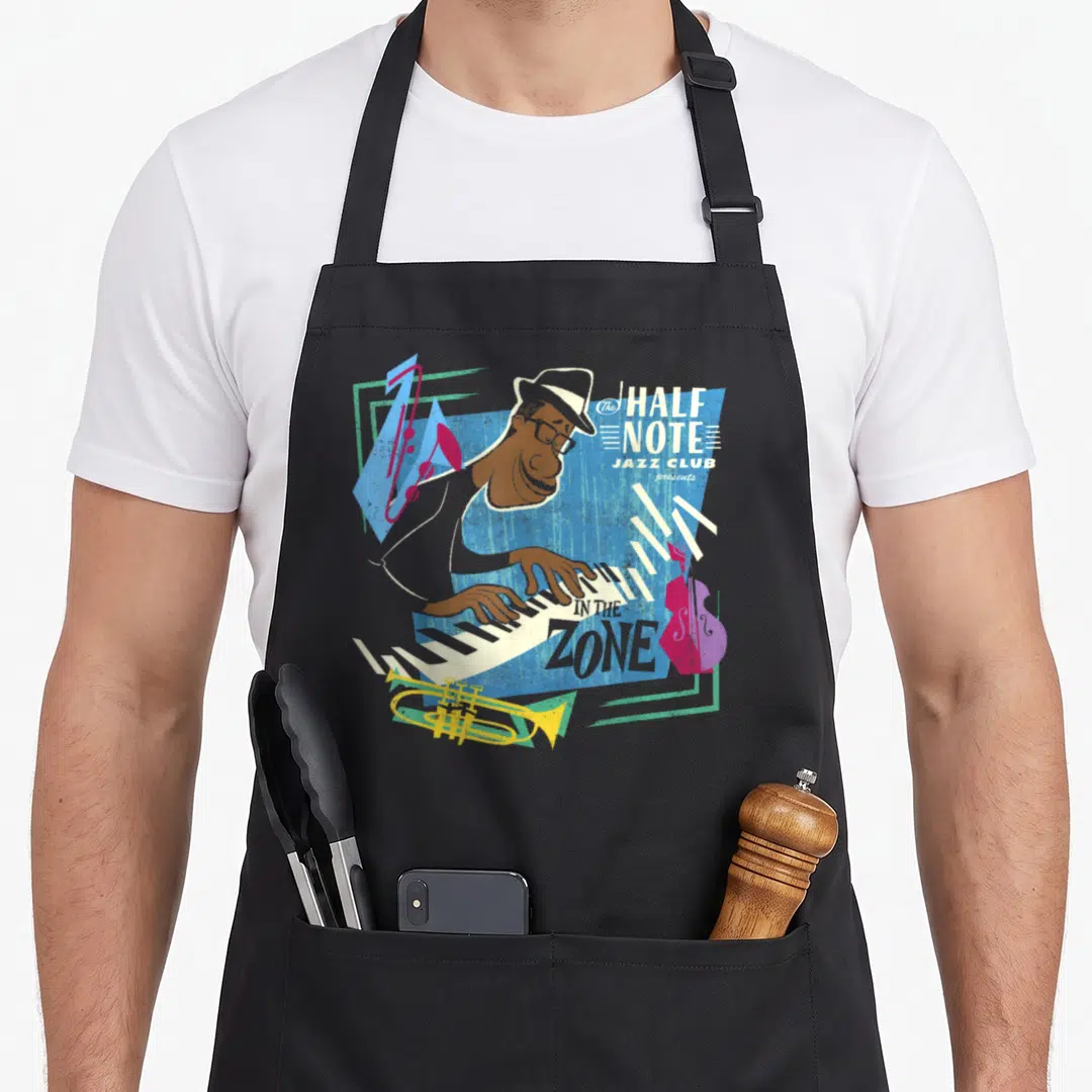 Soul jazz apron - Retro pianist playing keys with text The HALF NOTE JAZZ CLUB presents IN THE ZONE and scattered — shown on a black cotton canvas apron against a white background