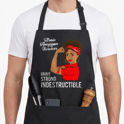 Survivor brain apron - Cartoon woman flexing arm with red bandana and Brain Aneurysm Survivor text — shown on a black cotton canvas apron against a white background