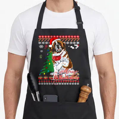 Saint ugly christmas sweater apron - Cartoon Saint Bernard in Santa hat with Merry Christmas text, candy canes — shown on a black cotton canvas apron against a white background
