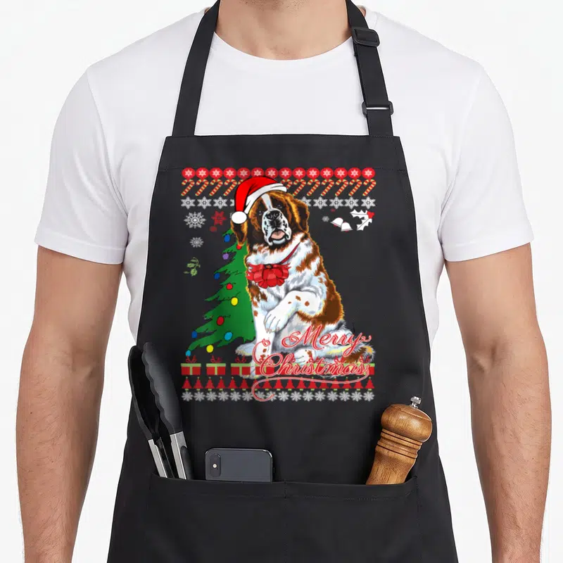 Saint ugly christmas sweater apron - Cartoon Saint Bernard in Santa hat with Merry Christmas text, candy canes — shown on a black cotton canvas apron against a white background