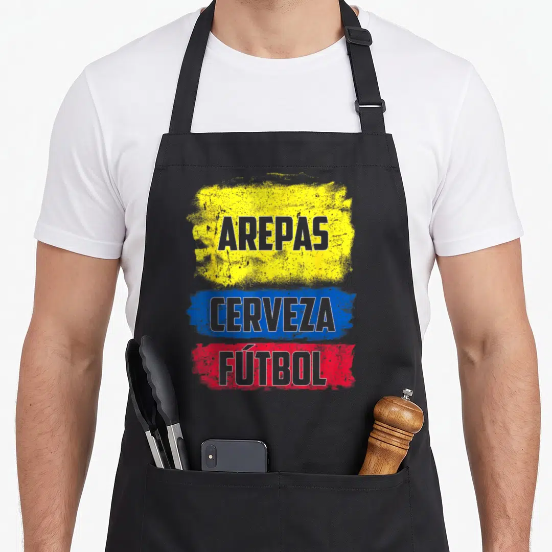 Cerveza arepas apron - Stacked text AREPAS CERVEZA FUTBOL on yellow blue red distressed brushstrokes — shown on a black cotton canvas apron against a white background