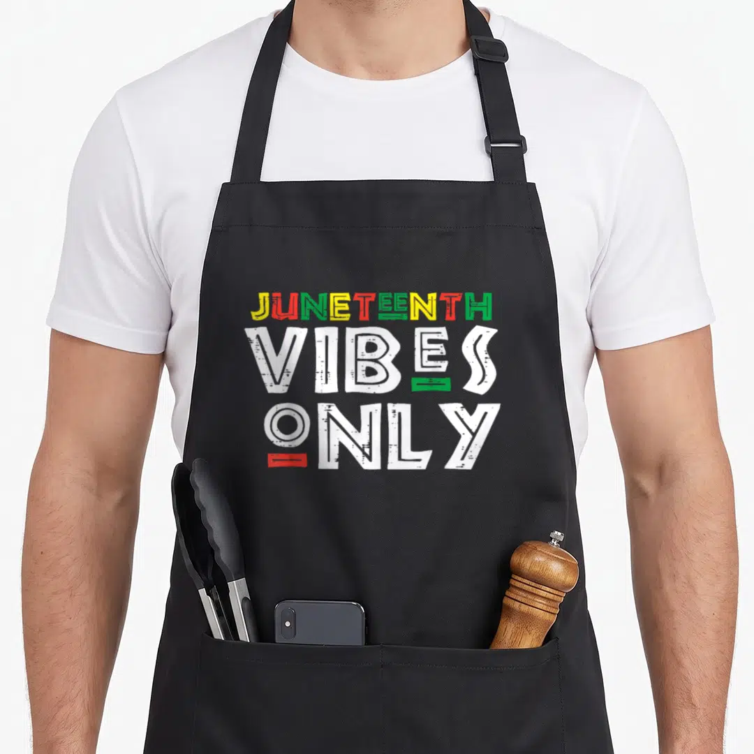 Juneteenth pride african apron - Stacked JUNETEENTH VIBES ONLY text in red green yellow and white distressed typography — shown on a black cotton canvas apron against a white background
