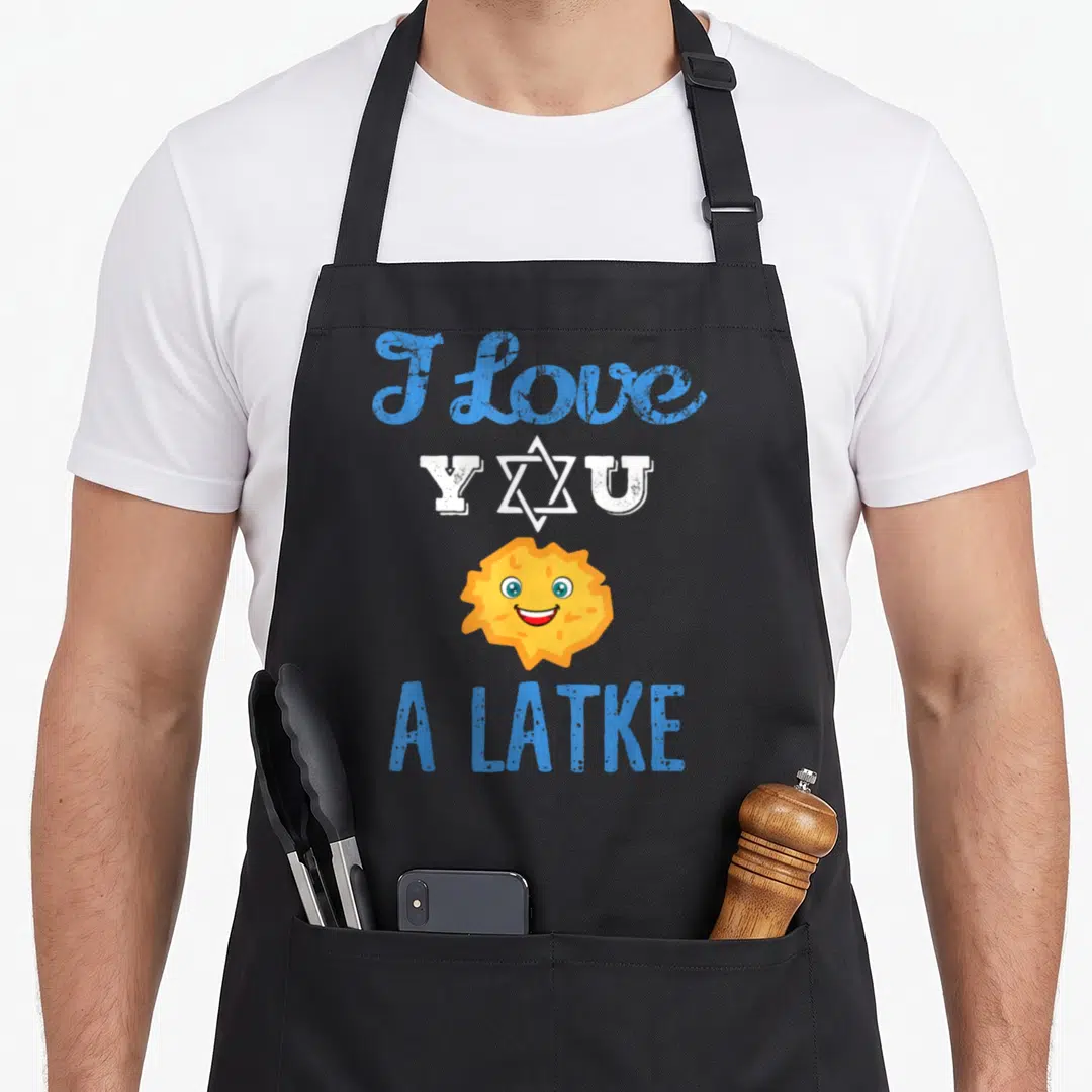 Latke passover apron - Stacked text I love Y U A LATKE with cartoon yellow latke and Star of David in blue and white — shown on a black cotton canvas apron against a white background