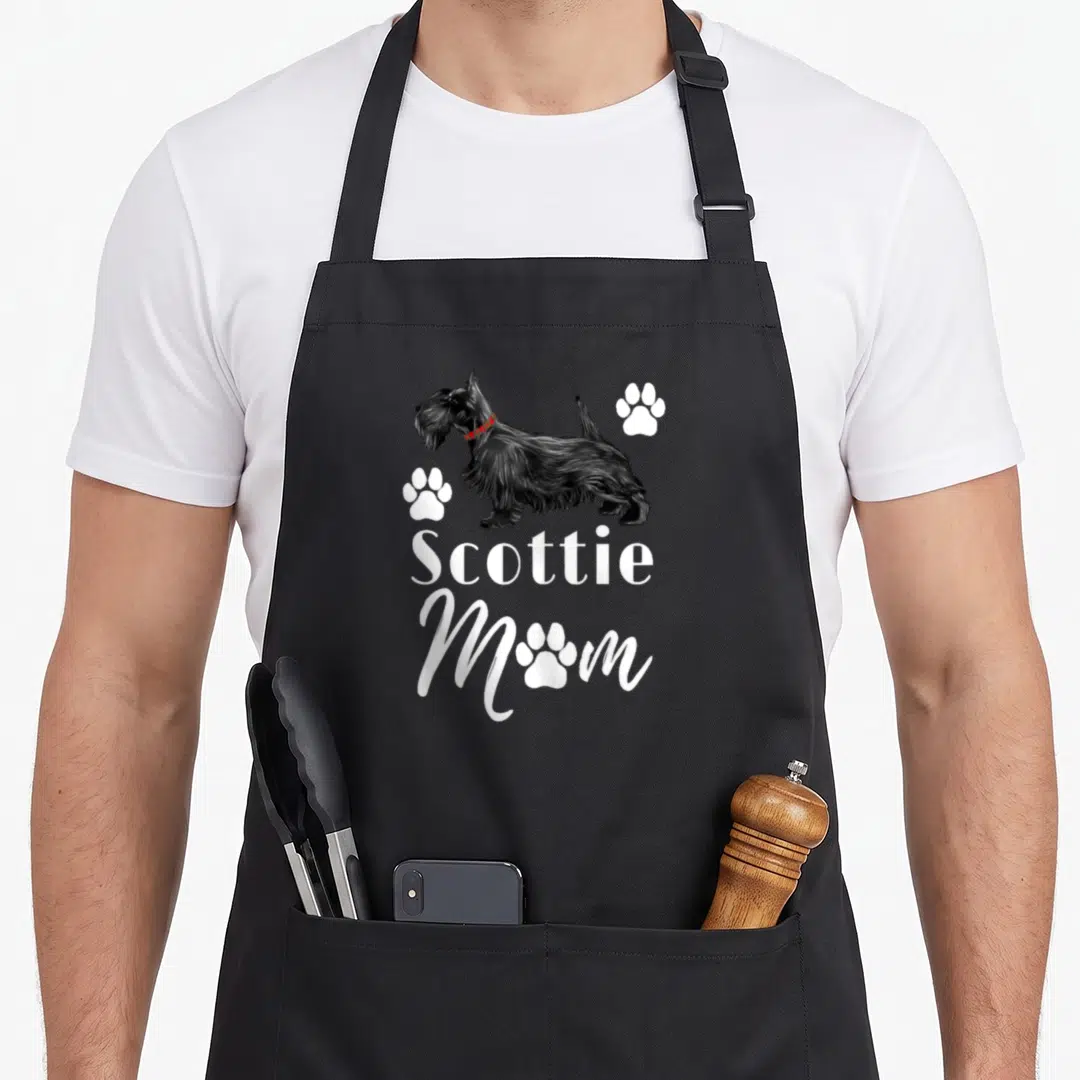Scottish terrier scottie dog apron - Black Scottish Terrier with red plaid collar and white Scottie Mom text surrounded — shown on a black cotton canvas apron against a white background