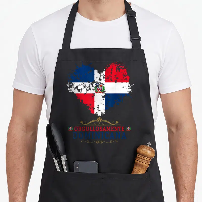 Arm dominican apron - Heart shaped Dominican flag with distressed paint splatter and Orgullosamente Dominicana text — shown on a black cotton canvas apron against a white background