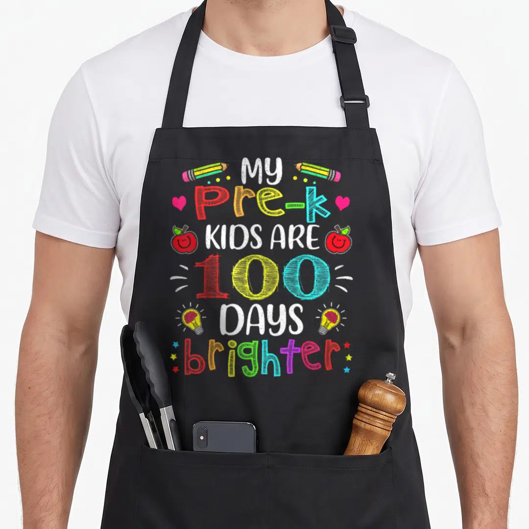 Brighter teacher apron - My Pre-K Kids Are 100 Days Brighter text with pencils, apples, and lightbulbs — shown on a black cotton canvas apron against a white background