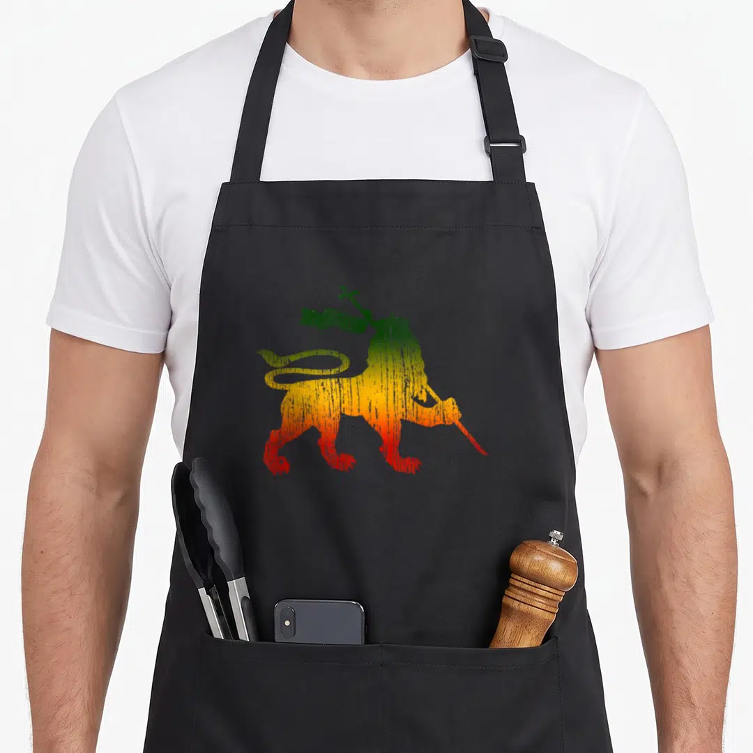 Judah rastafari lions apron - Distressed lion holding flag in green yellow red gradient — shown on a black cotton canvas apron against a white background