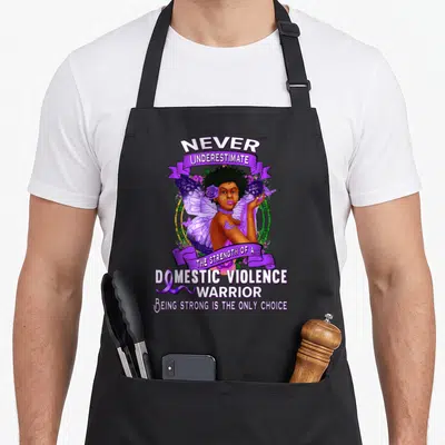 Violence awareness domestic aprons - Fairy woman framed by purple ribbons with text about domestic violence warrior — shown on a black cotton canvas apron against a white background