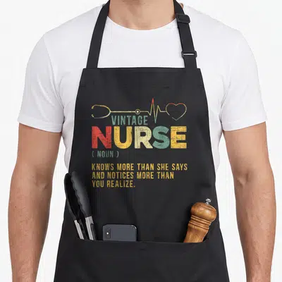 Definition nursing apron - Vintage nurse dictionary definition text with stethoscope and heartbeat line in olive green — shown on a black cotton canvas apron against a white background