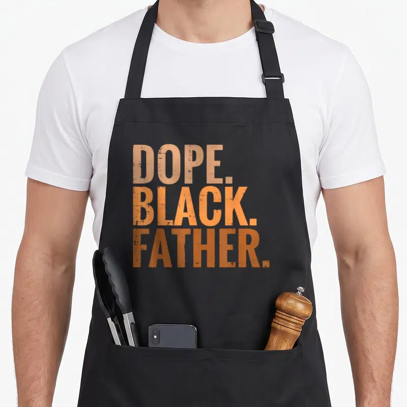 Dope african father day apron - Stacked tan orange and brown text reading DOPE BLACK FATHER — shown on a black cotton canvas apron against a white background
