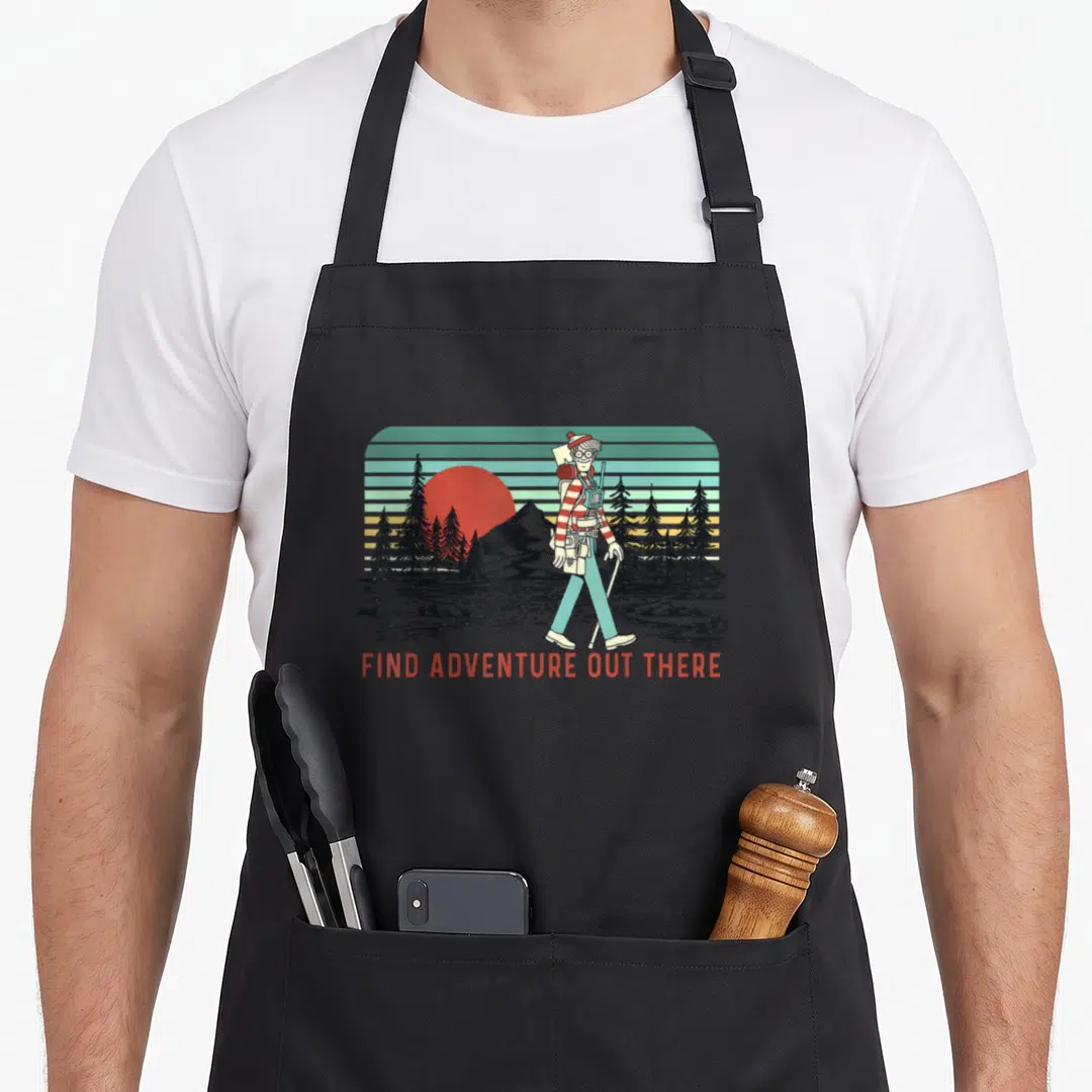 Waldo where to find aprons - Retro hiker in red stripes walking past trees and sun with 'FIND ADVENTURE OUT THERE' text — shown on a black cotton canvas apron against a white background