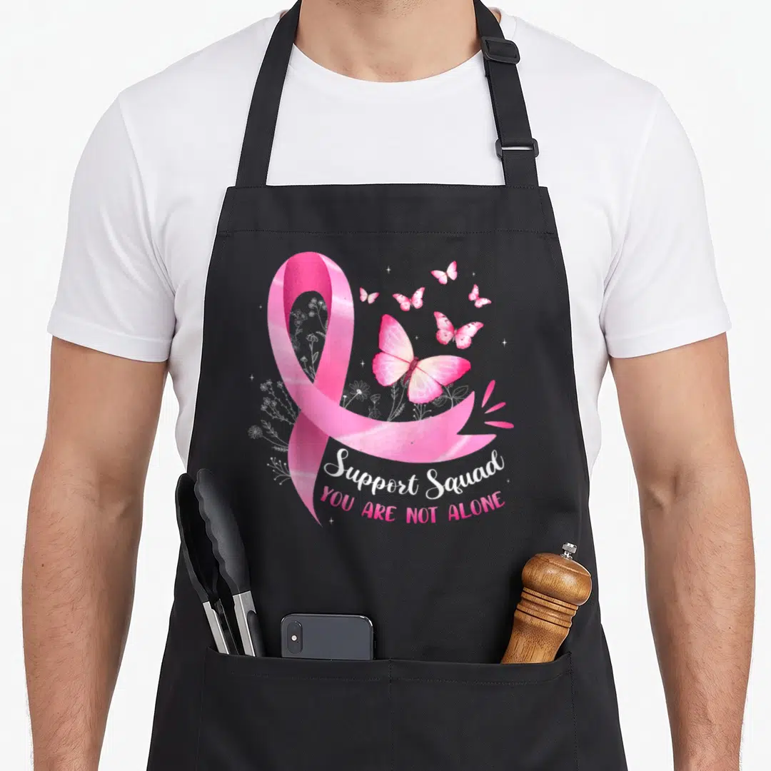 Bow breast cancer awareness aprons - Pink watercolor ribbon with butterflies and Support Squad text on black apron — shown on a black cotton canvas apron against a white background