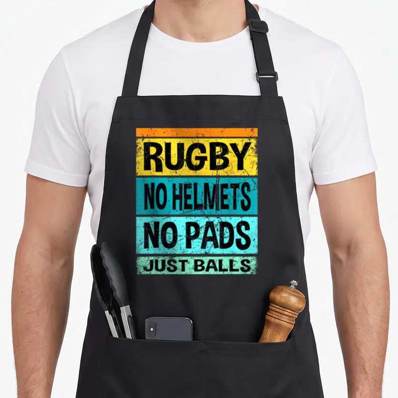 Ball rugby player apron - Rugby text on orange yellow blue cyan green distressed bands — shown on a black cotton canvas apron against a white background