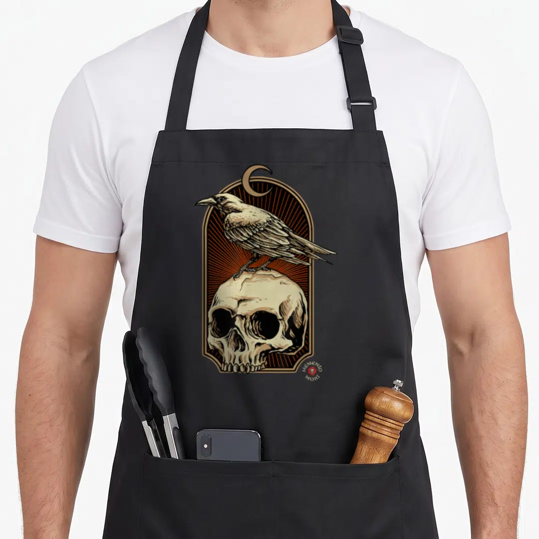 Skull ravens aprons - Line art of a beige crow standing on a skull under a crescent moon in an arch — shown on a black cotton canvas apron against a white background