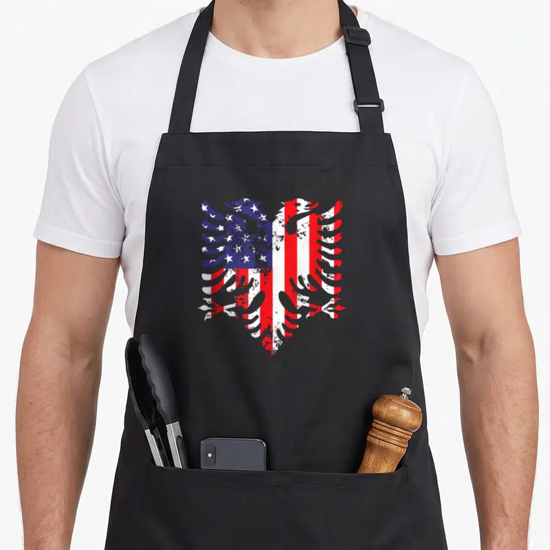 Albanian eagle american flag apron - Eagle silhouette filled with red white blue USA flag pattern in distressed style — shown on a black cotton canvas apron against a white background
