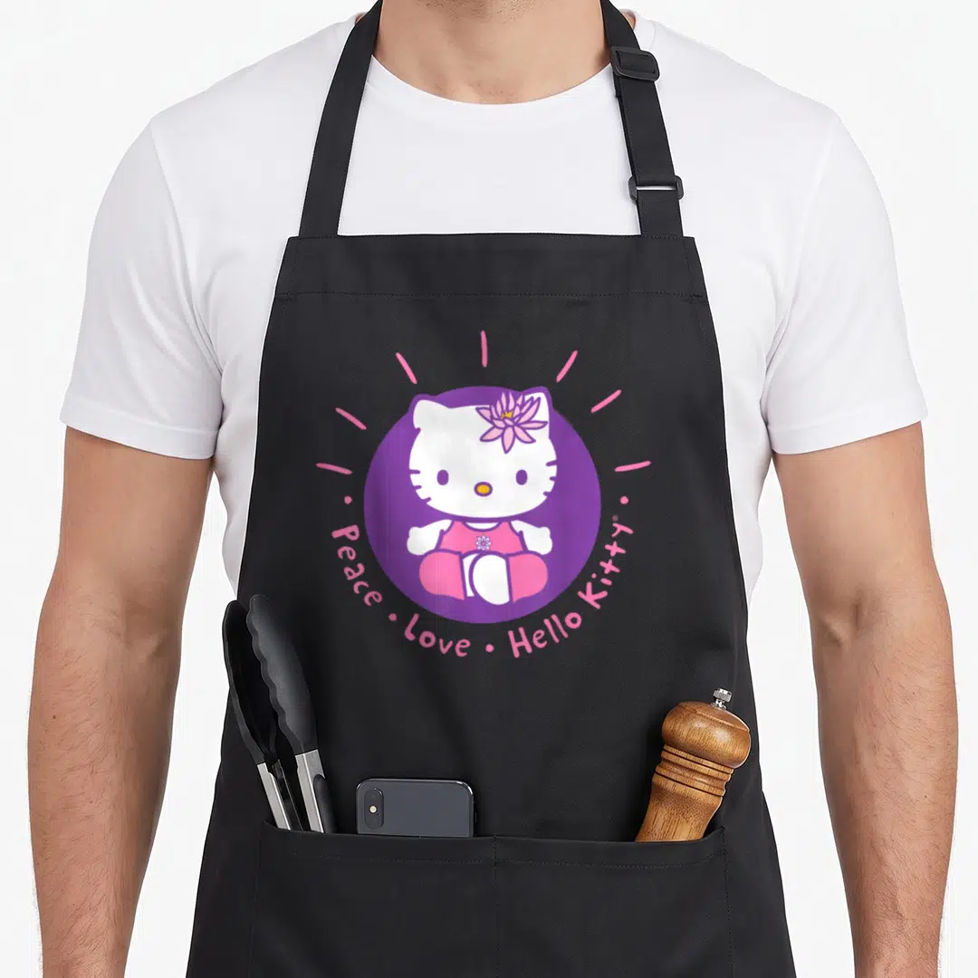 Peace lotus apron - Hello Kitty in purple circle with pink lotus and curved text — shown on a black cotton canvas apron against a white background