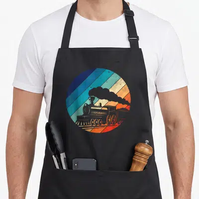 Railroad locomotive apron - Grey steam locomotive in circle of blue orange and red diagonal stripes retro style — shown on a black cotton canvas apron against a white background