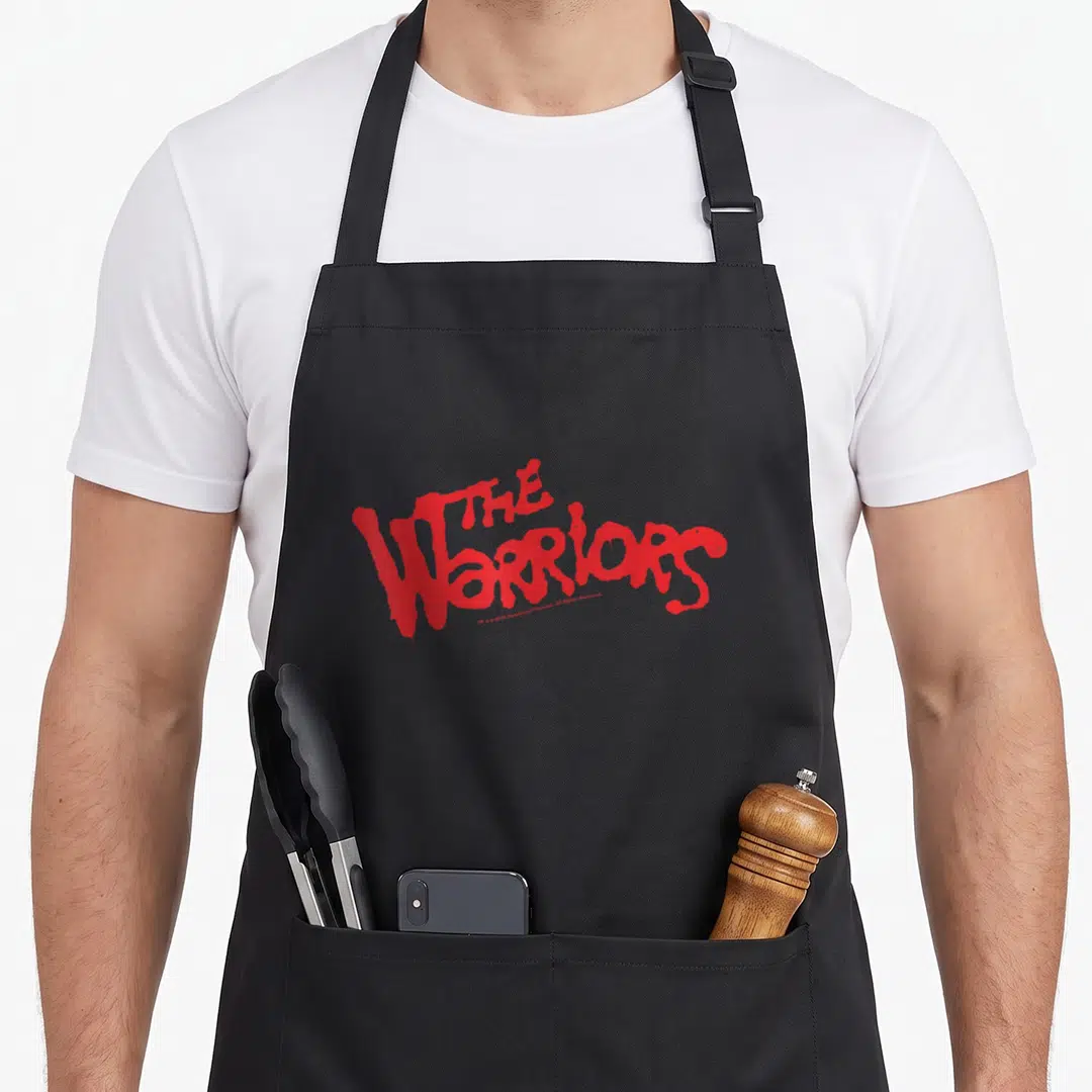 Warrior curry apron - Red dripping paint style text reading THE WARRIORS stacked on two lines — shown on a black cotton canvas apron against a white background