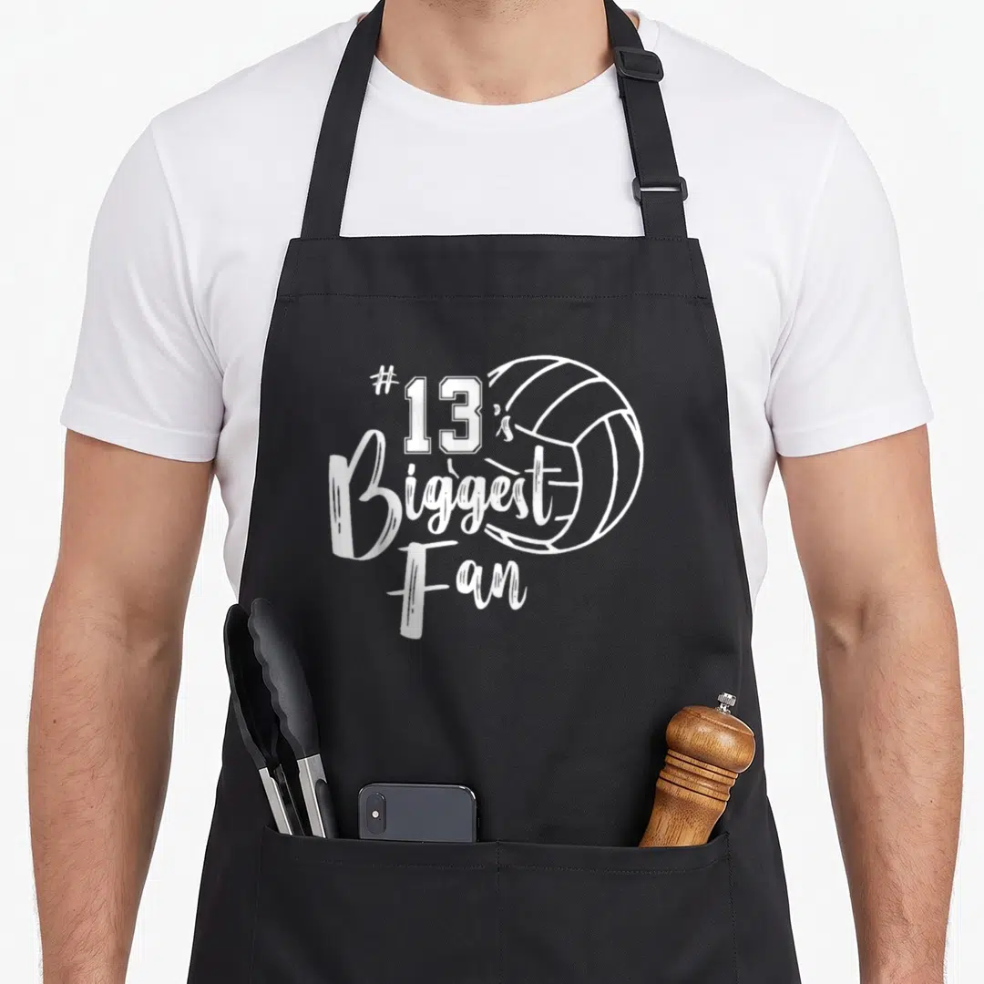 Thirteen volleyball dad apron - White line art volleyball and #13 is Biggest Fan text on black apron — shown on a black cotton canvas apron against a white background