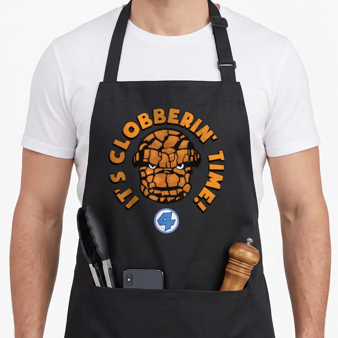 Fantastic face apron - Orange rocky head with arched text and blue number 4 logo — shown on a black cotton canvas apron against a white background