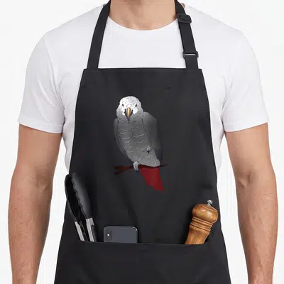 Perching african aprons - Grey parrot with white head and red tail perched on a brown cartoon branch — shown on a black cotton canvas apron against a white background