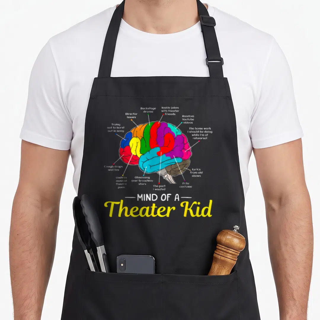 Mind theater apron - Multicolored brain diagram with text labels like director issues and cough drops — shown on a black cotton canvas apron against a white background